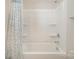 Close-up of a bathtub and shower combo with a shower curtain and storage shelves at 244 Aershire Ct, Concord, NC 28025