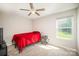 This bedroom features a ceiling fan, natural light from a large window, and carpet flooring at 244 Aershire Ct, Concord, NC 28025