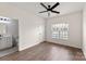 Bedroom featuring a ceiling fan, wood floors, a window providing natural light and a view to the bathroom at 2659 Captains Watch Ne Rd, Kannapolis, NC 28083