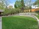 Well-maintained backyard features lush lawn, tiered retaining wall, and privacy fence at 2909 Hanson Dr, Charlotte, NC 28207