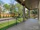 Expansive covered balcony showcasing sleek railings, stone pillars, and picturesque backyard views at 2909 Hanson Dr, Charlotte, NC 28207