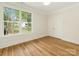 Inviting bedroom with hardwood floors, a large window with a view, and a closet with double doors at 2909 Hanson Dr, Charlotte, NC 28207