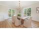 Bright dining room with modern chandelier, a wooden table, and French doors leading to the outside at 2909 Hanson Dr, Charlotte, NC 28207