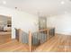 Upstairs hallway showcasing hardwood floors, a stylish chandelier, and modern railings at 2909 Hanson Dr, Charlotte, NC 28207