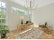 Bright home office featuring hardwood floors, neutral walls, large windows, and modern chandelier at 2909 Hanson Dr, Charlotte, NC 28207