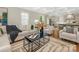 Open-concept living room with light furniture, stylish decor, and a view of the kitchen's bar seating at 2909 Hanson Dr, Charlotte, NC 28207