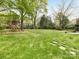 Expansive backyard featuring a wooden playset, a soccer net, and mature trees, perfect for outdoor activities at 2912 Wheelock Rd, Charlotte, NC 28211