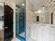 Well lit bathroom with a blue tiled shower and eye-catching wallpaper at 2912 Wheelock Rd, Charlotte, NC 28211