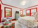 Bright bedroom with red trim and floral patterned arm chairs and bed at 2912 Wheelock Rd, Charlotte, NC 28211
