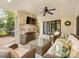 Relaxing covered patio with a brick fireplace, ceiling fan, and comfortable wicker seating and glass table at 2912 Wheelock Rd, Charlotte, NC 28211