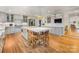 Open-concept kitchen featuring a large island with seating, stainless steel appliances, and hardwood floors at 2912 Wheelock Rd, Charlotte, NC 28211