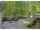 Serene backyard with gravel, mature trees, and a charming white fence at 2915 Cross Country Rd, Charlotte, NC 28270
