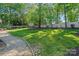 Large backyard with mature trees, level yard, and landscaping features at 2915 Cross Country Rd, Charlotte, NC 28270