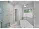 Bright bathroom with a freestanding tub, glass shower, and natural light at 2915 Cross Country Rd, Charlotte, NC 28270