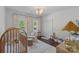 Comfortable Bedroom with natural light, a crib and a cushioned chair complemented by hardwood floors at 2915 Cross Country Rd, Charlotte, NC 28270