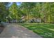 Wide shot of a traditional-style home surrounded by lush, mature trees and a well-manicured lawn at 2915 Cross Country Rd, Charlotte, NC 28270