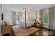Serene main bedroom features a four-poster bed, hardwood floors, and large windows with leafy views at 2915 Cross Country Rd, Charlotte, NC 28270