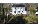 A white two-story home features an expansive backyard with mature trees and green grass at 314 Bass Ln, Charlotte, NC 28270