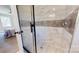 Glass enclosed tiled shower with modern fixtures and a partial bedroom view at 314 Bass Ln, Charlotte, NC 28270