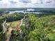 Aerial view showcasing the home nestled within lush trees and overlooking a serene lake at 3160 Ashwood Park Dr, Belmont, NC 28012