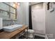 Unique bathroom with rustic wood counter, vessel sink, and a subway tile shower, creating a charming and modern space at 3160 Ashwood Park Dr, Belmont, NC 28012
