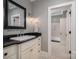 Stylish bathroom with a black marble countertop, patterned floors, and a framed mirror, exuding elegance and comfort at 3160 Ashwood Park Dr, Belmont, NC 28012
