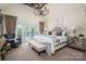 Elegant bedroom featuring a tufted headboard, chandelier, and French doors leading to a private balcony at 3160 Ashwood Park Dr, Belmont, NC 28012