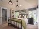 Cozy bedroom with a metal frame bed, complemented by natural light and framed artwork, offering comfort and charm at 3160 Ashwood Park Dr, Belmont, NC 28012