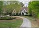 Landscaped lawn leading to a house featuring manicured greenery and a circular driveway at 3160 Ashwood Park Dr, Belmont, NC 28012