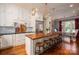 Kitchen features white cabinets, hardwood floors, large central island and stainless steel refrigerator at 3160 Ashwood Park Dr, Belmont, NC 28012