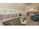 Cozy living room with a sectional sofa, plush ottoman, and kitchenette, perfect for relaxation and casual gatherings at 3160 Ashwood Park Dr, Belmont, NC 28012