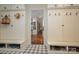 Well-organized mudroom with built-in storage, coat hooks, and checkered tile flooring at 3160 Ashwood Park Dr, Belmont, NC 28012