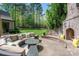 Inviting outdoor patio with ample seating, brick fireplace, and beautiful views of the green lawn at 3160 Ashwood Park Dr, Belmont, NC 28012