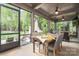 Screened-in porch with stone fireplace, ceiling fans, and wood dining table at 3160 Ashwood Park Dr, Belmont, NC 28012