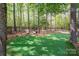Private putting green with lush turf and wooded surround, creating a serene backyard amenity at 3160 Ashwood Park Dr, Belmont, NC 28012