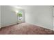 Bright carpeted bedroom featuring a window and closet at 3320 Alderknoll Ct, Charlotte, NC 28216