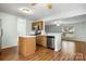 Open kitchen and living area with wood floors, stainless steel appliances, and natural light at 3320 Alderknoll Ct, Charlotte, NC 28216