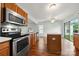 Well-lit kitchen features stainless steel appliances, wood cabinets, and sliding glass doors to the backyard at 3320 Alderknoll Ct, Charlotte, NC 28216
