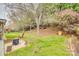 Picturesque backyard with a cozy fire pit, lush lawn, and flowering trees offering serene outdoor living at 3383 Norwich Rd, Fort Mill, SC 29715