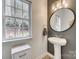 Stylish powder room featuring a pedestal sink, modern mirror, and natural light at 3383 Norwich Rd, Fort Mill, SC 29715