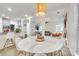 Bright dining area with a large round table, stylish lighting, and an open layout to the living area at 3383 Norwich Rd, Fort Mill, SC 29715