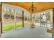 Relaxing screened-in patio with wood ceiling, decorative chandelier, and backyard view at 3383 Norwich Rd, Fort Mill, SC 29715