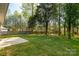 Spacious backyard featuring mature trees and a concrete patio at 3411 Xandra Ct, Indian Land, SC 29707