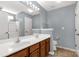 Bathroom featuring double sinks, large mirror, white tile shower and toilet at 3411 Xandra Ct, Indian Land, SC 29707