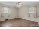 A sunny bedroom features wood-look floors, ceiling fan and two windows at 394 Efird St, Gastonia, NC 28054