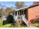 Charming brick home featuring a welcoming front porch with white railings and lush landscaping at 394 Efird St, Gastonia, NC 28054