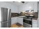 An efficient kitchen shows white cabinets, stainless appliances and wood-look flooring at 394 Efird St, Gastonia, NC 28054