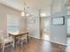 The open-concept dining room boasts hardwood floors, neutral walls, natural light, and view to the kitchen at 4130 Town Center Rd, Harrisburg, NC 28075