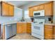 Bright kitchen showcases oak cabinets, white appliances, and a sunny window for meal preparation at 4130 Town Center Rd, Harrisburg, NC 28075