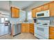 Cozy kitchen featuring honey oak cabinetry, white appliances, and neutral countertops for a warm and inviting space at 4130 Town Center Rd, Harrisburg, NC 28075